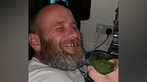 David Hunt smiling at the camera while holding a glass