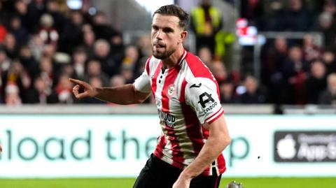 Jordan Henderson holds out his hand to celebrate scoring a goal