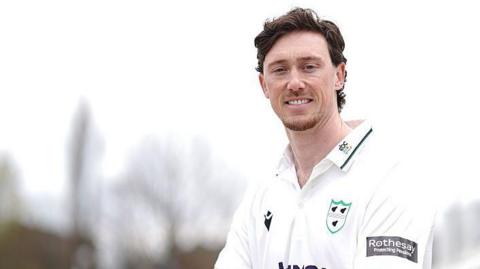 Adam Hose poses in the seats of the Basil D'Oliveira Stand at New Road