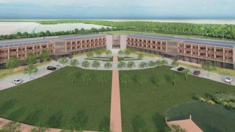An artists impression of Doncaster City Elite Training Centre, taken from the planning document. It depicts a large green area, with trees in the foreground with a peach coloured pathway through the centre, and car parking at either side. At the apex of the image is a hotel like structure in four, wide. three storey blocks, edged with trees.