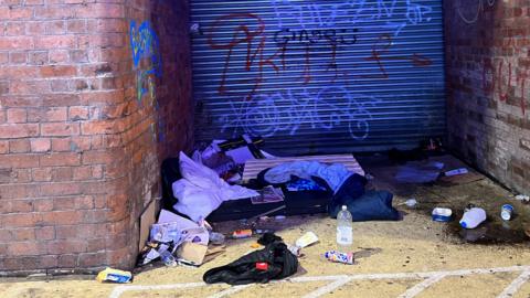 A sleeping bag and other items in a doorway