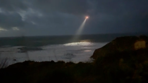 A helicopter with a strong search line flies over Newquay
