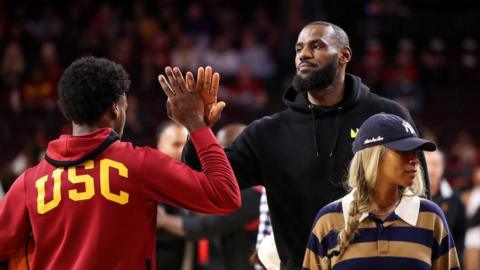 LeBron James high-fives his son Bronny