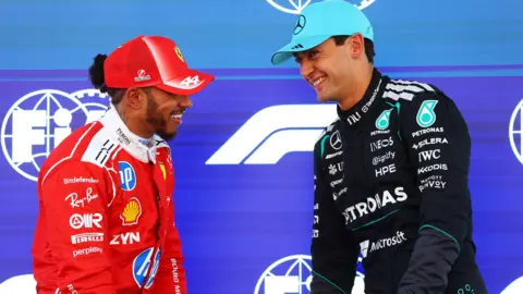 Ferrari's Lewis Hamilton and Mercedes' George Russell share a joke after qualifying for the Barcelona-Catalunya Grand Prix