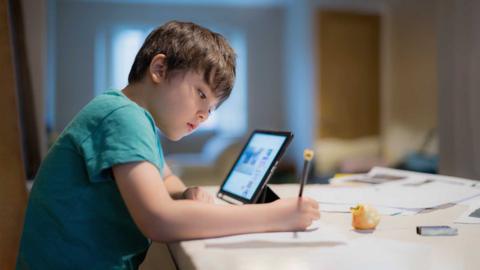 Young boy doing his homework with a laptop