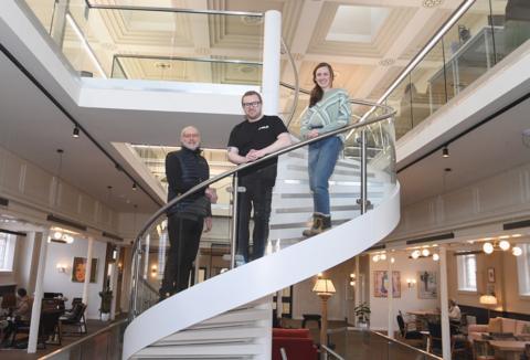 Three people standing on a staircase