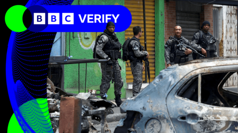 Armed police officers in front of burnt out cars