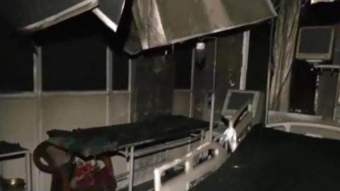 A charred hospital room with two beds, monitors and some broken equipment hanging from above after the fire incident on 5 October