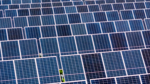 An array of solar panels in a field.