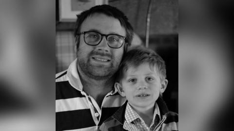 A black and white photo of Tom and Rupert when he was younger. They are both in hooped tops with collars.