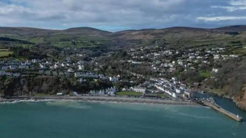 An aerial view of Garff, you can see the coastline, and houses scattered along the hilly terrain.