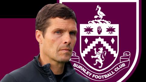 Mike Jackson, in front of a claret and black background and the Burnley club badge