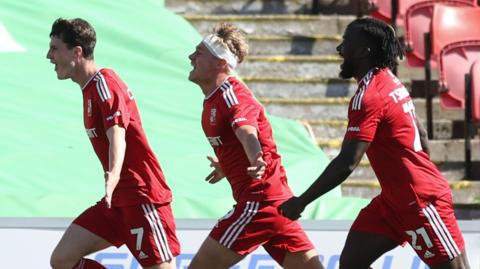 Joel Cotterill, Paul Glatzel and Kabongo Tshimanga of Swindon Town celebrate