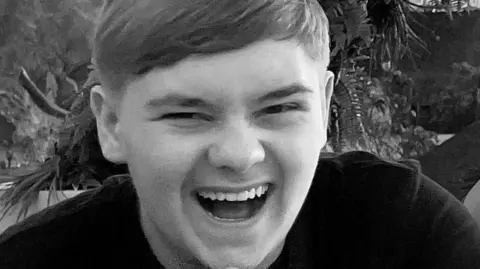 Black and white close-up image showing Harvey Willgoose smiling