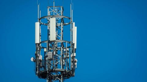 A mast with several white boxes on it.