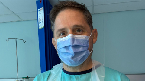 Rhys Thomas wearing a medical mask and apron
