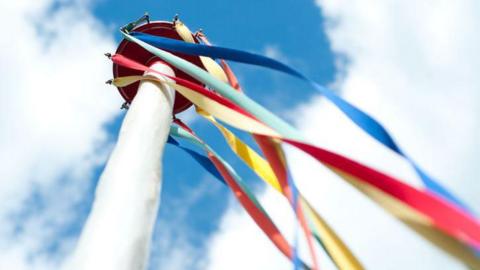 A maypole with colourful ribbons.