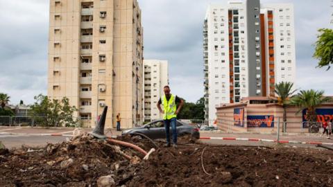 Residents and Israeli officials inspect the damage following an overnight rocket attack in Haifa, Israel (7 October 2024)