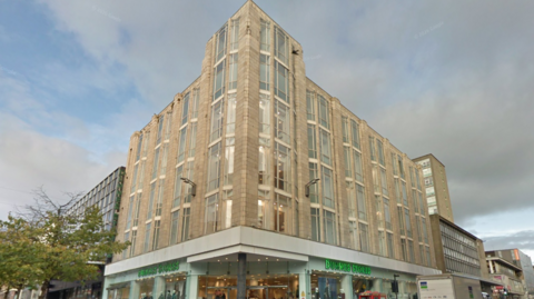 A large, empty high street building with an Art deco design