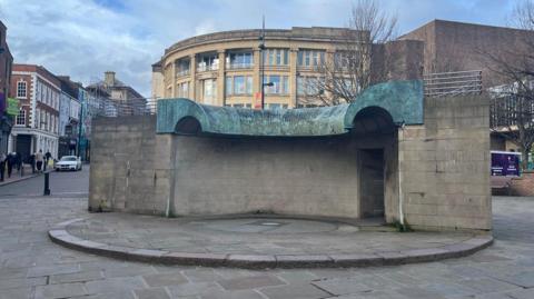 A concrete fountain with no water running from it.