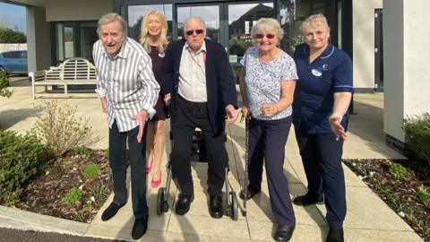 Care home residents (left to right front row) Phil Edwards, Leonard Symonds and Ann Moore, from Heathland House are posing in front of the building to show they are set to Race Across Dorset. Deputy manager Sarah Gibson Clarke is beside them. Deborah Holmes is in the back row.