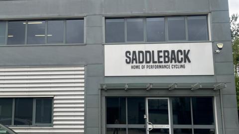 This picture was taken outside Saddleback's office/headquarters. The building uses two colours grey and silver. Underneath the company sign it reads, "home of performance cycling"