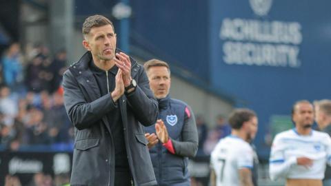 John Mousinho applauds Portsmouth's travelling fans after his side is beaten at Ipswich