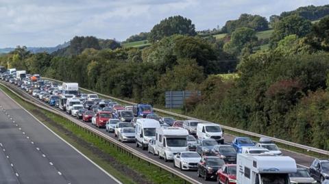 M5 taken from bridge above with long lines of traffic to the left and only a few cars in the carriageway to the right