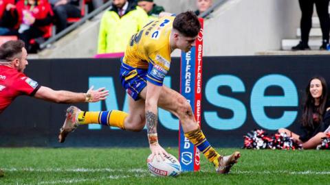 Leeds Rhinos' Riley Lumb scoring a try past the despairing dive of Salford's Ryan Brierley.