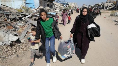 People carry their belongings as displaced Palestinians ordered by the Israeli military to evacuate the northern part of Gaza flee amid an Israeli military operation