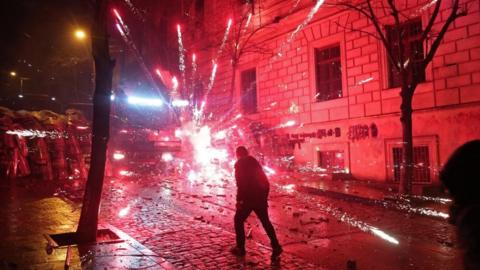 Fireworks explode near law enforcement officers during a protest