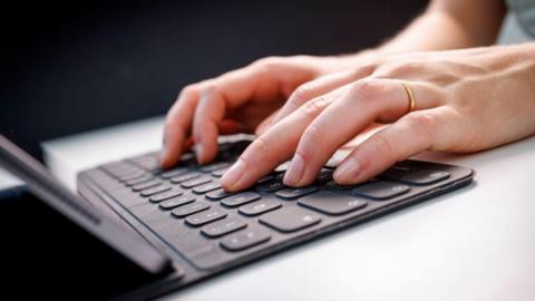 Library picture of two hands typing on a laptop