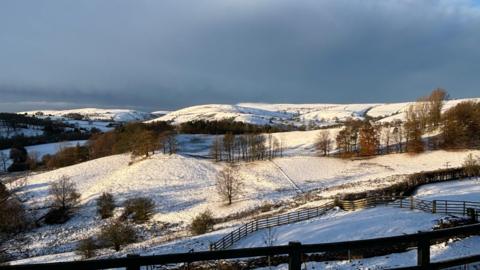 A view of snowy fields and trees in Whaley Bridge