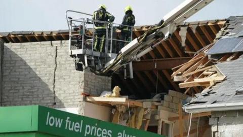 Two firefighters are seen near the blast site in October 2022