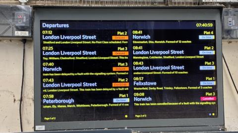 A digital train announcement board showing services with cancelled or delayed labels.