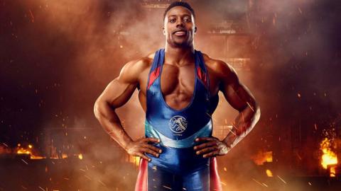 Nitro in Gladiator pose with hands on hips and fire behind him.