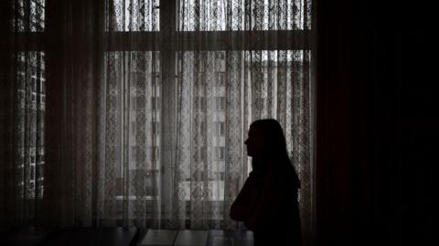 Silhouette of a woman by a window