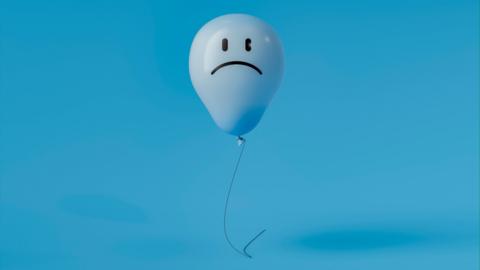 A blue balloon with a sad face on a blue background