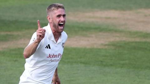 Olly Stone celebrates taking a wicket for Nottinghamshire.
