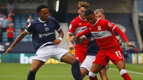 Two Middlesbrough players and two Millwall players battle for possession during their EFL Championship encounter at the New Den in London.