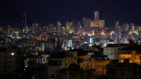 A nighttime view of Beirut’s illuminated cityscape, showcasing densely packed buildings and high-rise towers against the dark sky, after a ceasefire between Israel and Iran-backed group Hezbollah took effect at 02:00 GMT. 