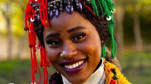 A woman poses for a picture during celebrations of the Amazigh New Year 2975 in traditional costume