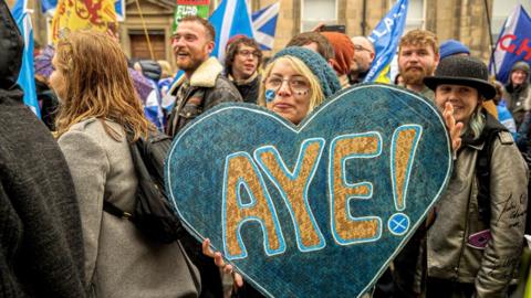 Woman with banner saying "aye"