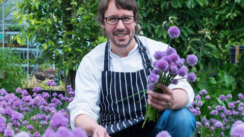 Chef with purple flowering chives