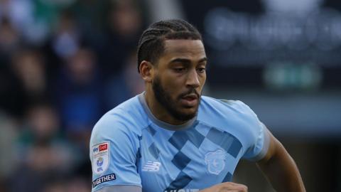 Andy Rinomhota playing for Cardiff City in a light blue away kit