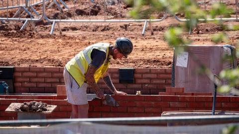 A man laying bricks on a construction site