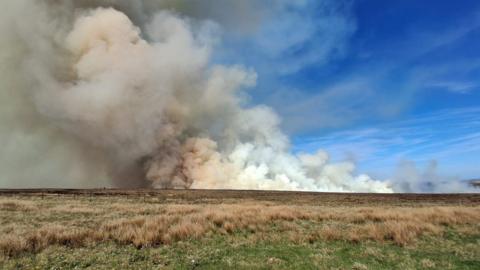 A huge cloud of smoke from a fire on moorland