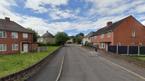 Part of a crescent side street in a residential area, lined with semi detached houses