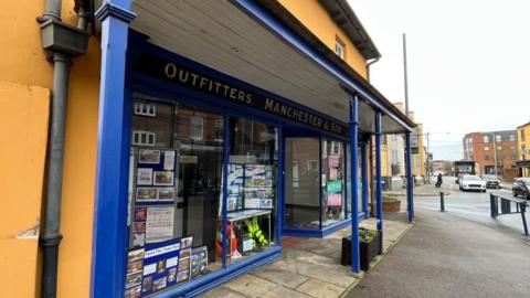 A front view of the dintinctive yellow building King Street in Melton Mowbray. The building has a blue frontage.