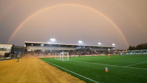 Newport County's ground Rodney Parade with a rainbow in the background.